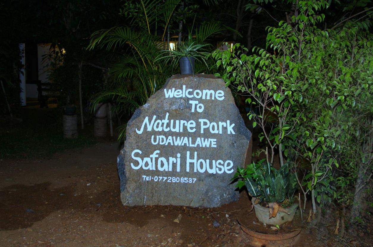 Señal de bienvenida de Nature Park UdaWalame Safari House con un número de contacto.