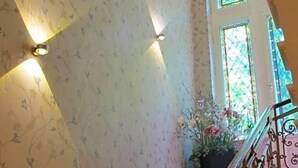 A staircase with a floral wallpaper design, a potted plant, and a railing. - Hotel Anlage Heidelberg (Heidelberg)