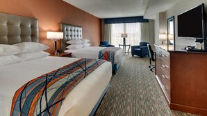 A hotel room with two beds, a desk with a flat-screen TV, a chair, and a large mirror. - Drury Inn & Suites Knoxville West (Knoxville)