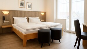 A modern bedroom with a wooden bed, two bedside tables, a desk, and a chair. - Hotel Orthwein (Coelbe)