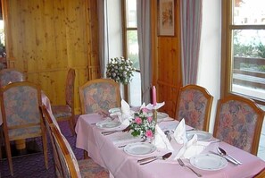 A dining table set with plates, cutlery, and a centerpiece.