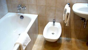 A bathroom with a bathtub, a bidet, and a sink.