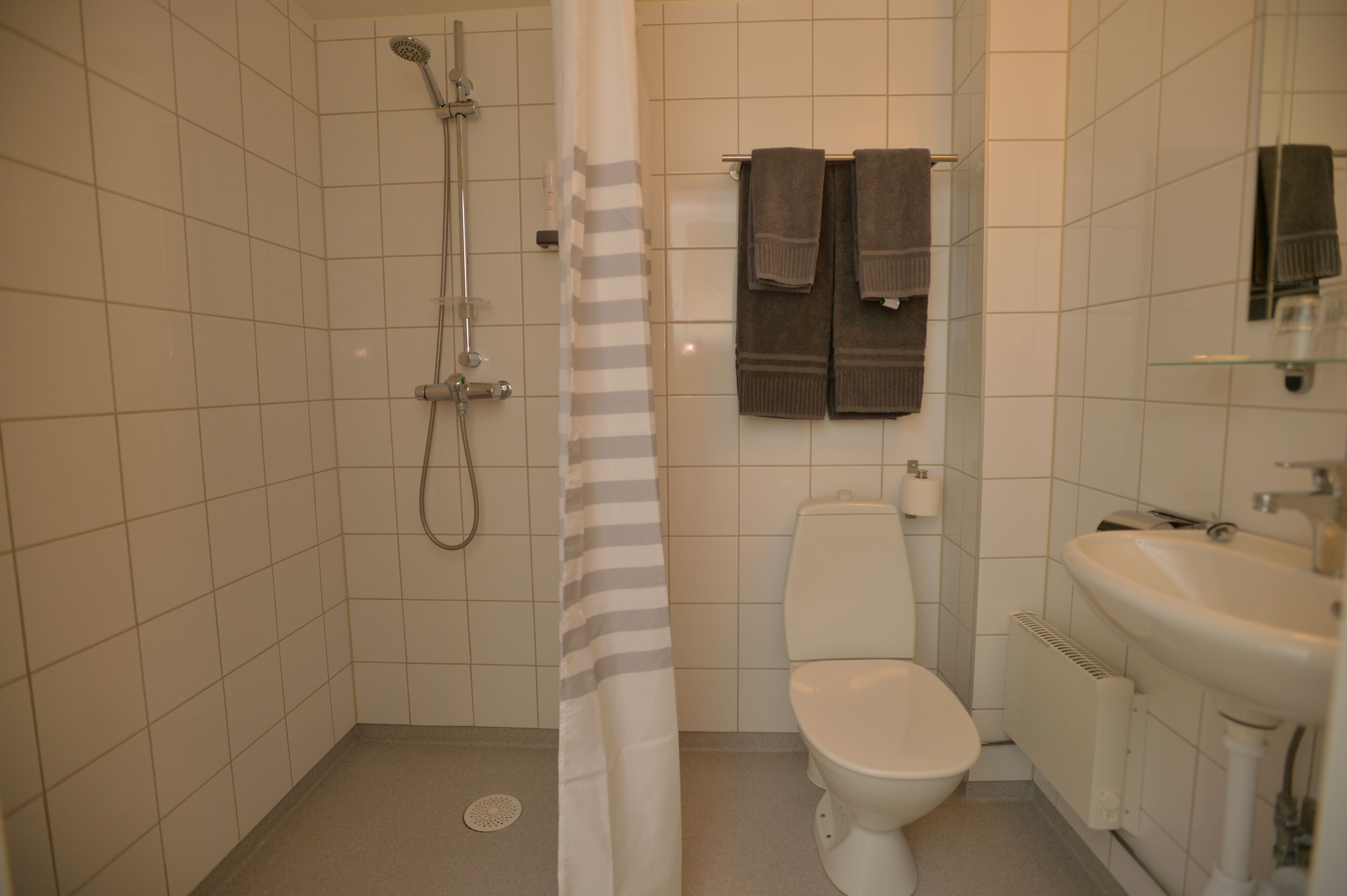 Ein Badezimmer mit Dusche, Toilette und Waschbecken.