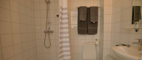 Ein Badezimmer mit Dusche, Toilette und Waschbecken.