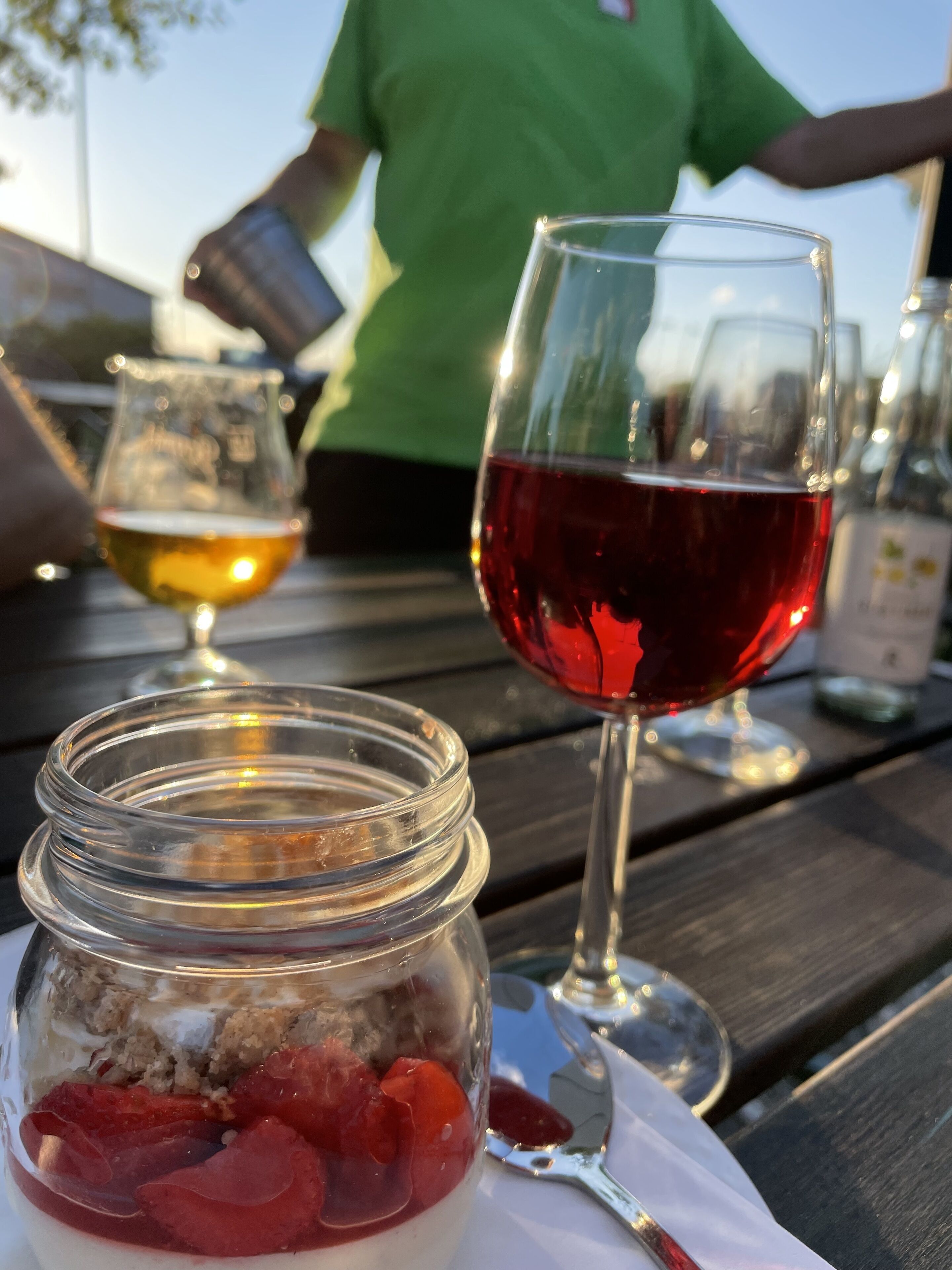A table with a jar of food, a glass of red wine, and a glass of white wine.