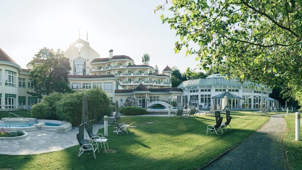 A large, luxurious estate with a swimming pool, outdoor seating, and a well-maintained lawn. - Reduce Hotel Thermal (Bad Tatzmannsdorf)