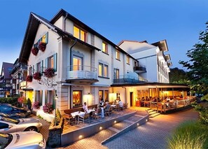 Un hôtel doté d’une terrasse extérieure, d’un patio couvert et d’une façade en pierre.