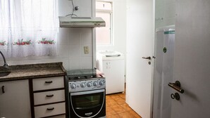 A kitchen with a stove, oven, and a refrigerator. - Habitat Ed. Diomício 1203 Urbano (Florianópolis)