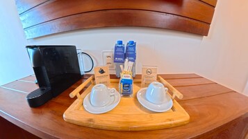 A breakfast setup with a coffee machine, two cups, a tray with condiments, and a sign indicating no smoking.