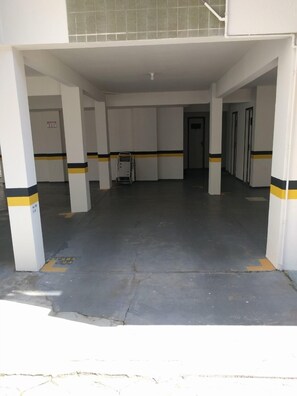 Open-plan area with high ceiling and smooth floor, supported by white pillars.