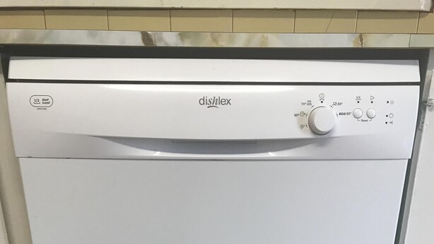 A white dishwasher with the brand 'dishlex' and a control panel with various settings.