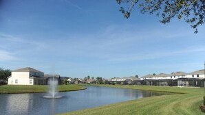 Um bairro residencial com lago, casas e um edifício com fonte.