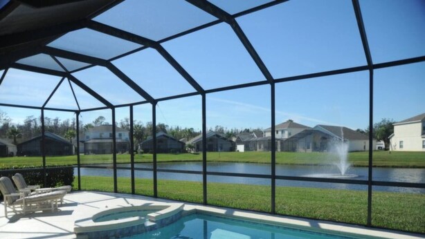 Piscina com vista clara para uma fonte e casas ao fundo.