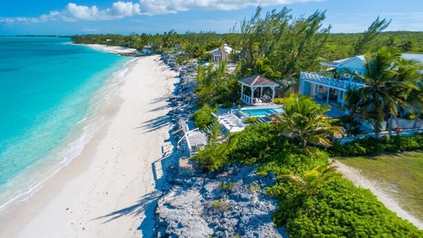 A beachfront property with a swimming pool, lounge chairs, and a gazebo. - Beachfront 5BR Villa w/ Pool | George Town, Exuma | Bajamar (Moss Town)