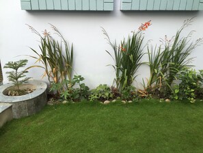 A garden with various plants and a stone planter. - Delights Home run by local host situated in a peaceful area of Kathmandu. (Kathmandu)