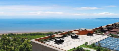 A rooftop terrace with outdoor seating and a view of the sea.