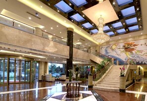 A spacious lobby with a grand chandelier, a mural, and a staircase. - Fuzhou Fliport Garden Hotel (Fuzhou)