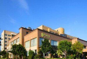 A multi-story building with a prominent sign, surrounded by greenery. - Fuzhou Fliport Garden Hotel (Fuzhou)
