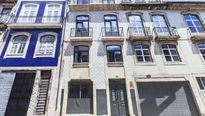 A row of multi-story buildings with balconies, large windows, and a garage door. - Apartment with Terrace One bedroom for 2 people and a sofa bed for 2 people (Porto)