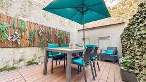 An outdoor patio with a table and chairs, a large umbrella, and various plants. - Apartment with Terrace One bedroom for 2 people and a sofa bed for 2 people (Porto)