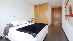 A modern bedroom with a large bed, a wooden wardrobe, and a painting on the wall. - House special for families and friends to 100 mt. of the sea. (Colonia de Sant Pere)