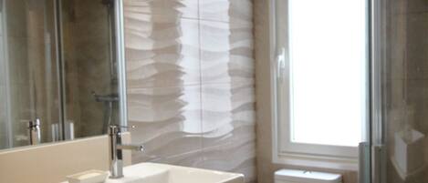 Regadera, toallas, shampoo, papel de baño