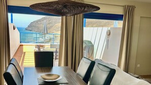 A dining area with a view of the sea, a ceiling fan, and a table set for two. - AMAZING SEA VIEW LUXURY APARTMENT- WITH SUN DRENCHED SPACIOUS TERRACE/FREE WiFi (Gran Tarajal, Tuineje)