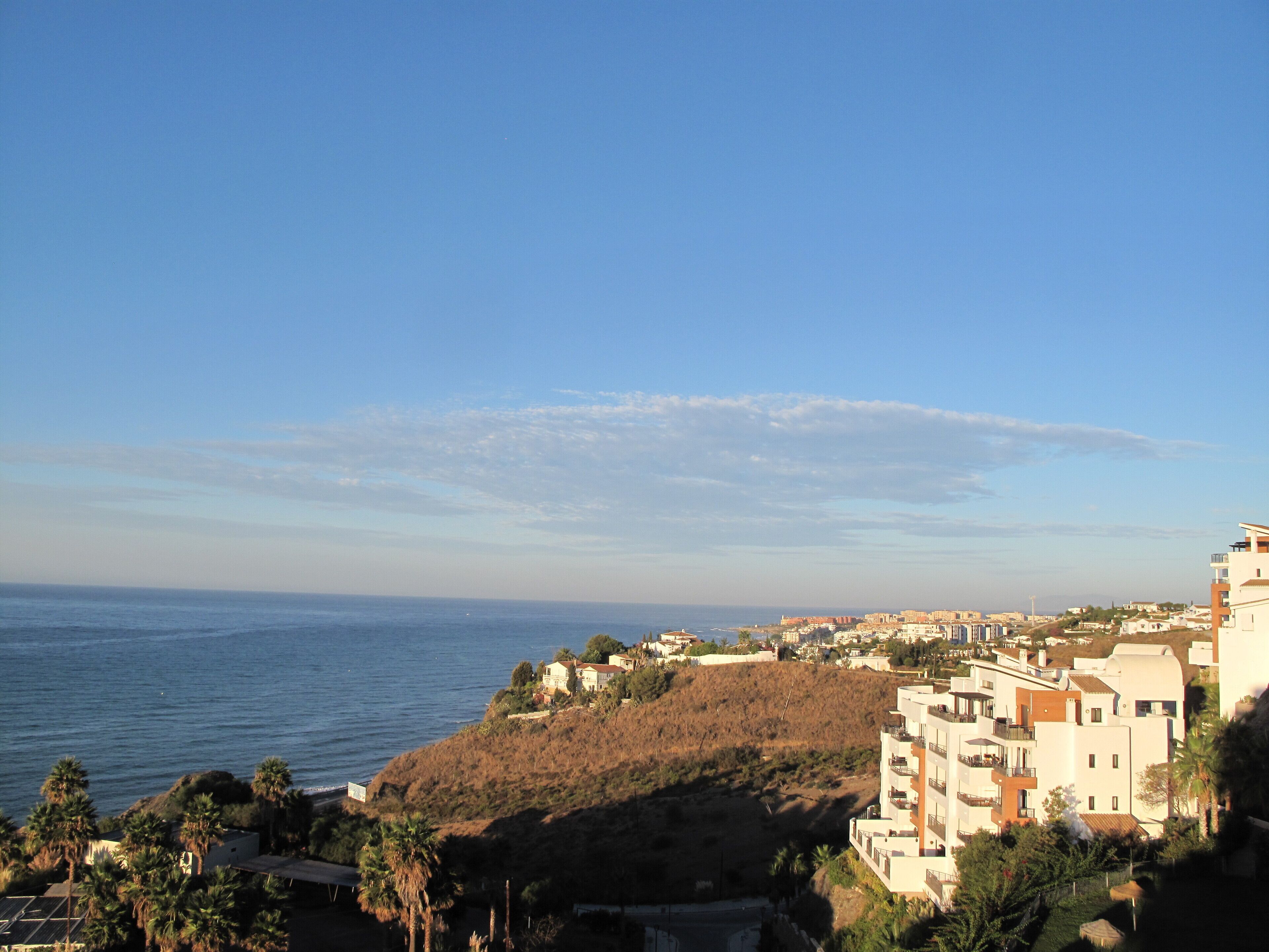 A coastal town with buildings on a hillside overlooking the sea.