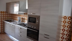 Una cocina moderna con electrodomésticos de acero inoxidable, horno empotrado y microondas.