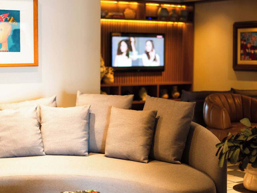 A modern living room with a curved sofa, a coffee table, and a flat-screen TV.