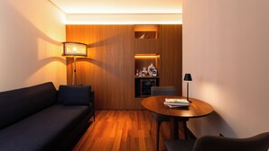 Una habitación moderna con un sofá, una mesa redonda y una lámpara.