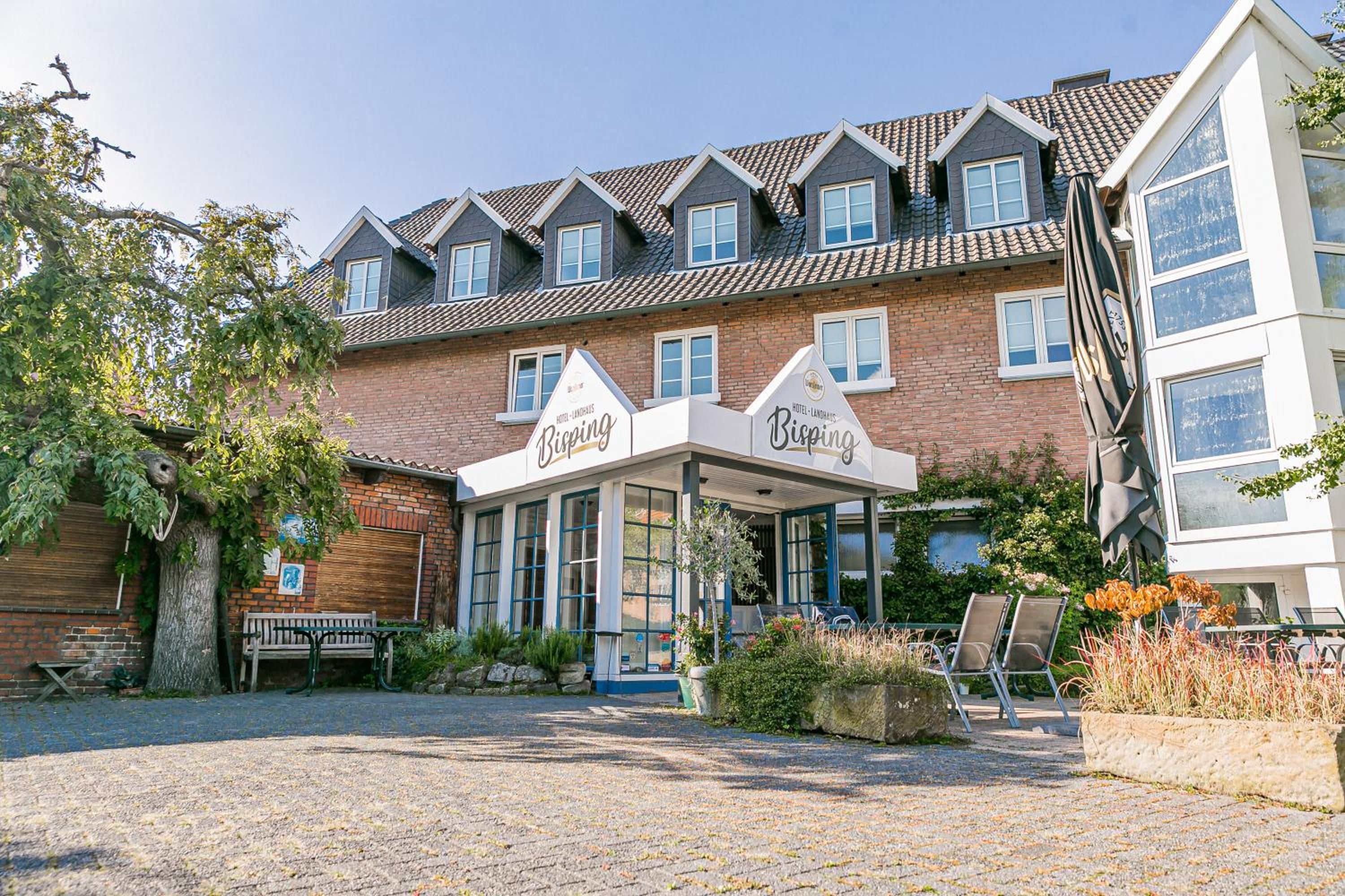 A hotel with a traditional brick facade, multiple windows, and a covered entrance area.