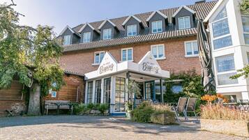 A hotel with a traditional brick facade, multiple windows, and a covered entrance area.