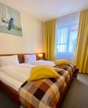 A hotel room with a large bed, two pillows, a nightstand, a lamp, and a window with curtains. - Hotel Zum Roten Lv Wen (Hildisrieden)