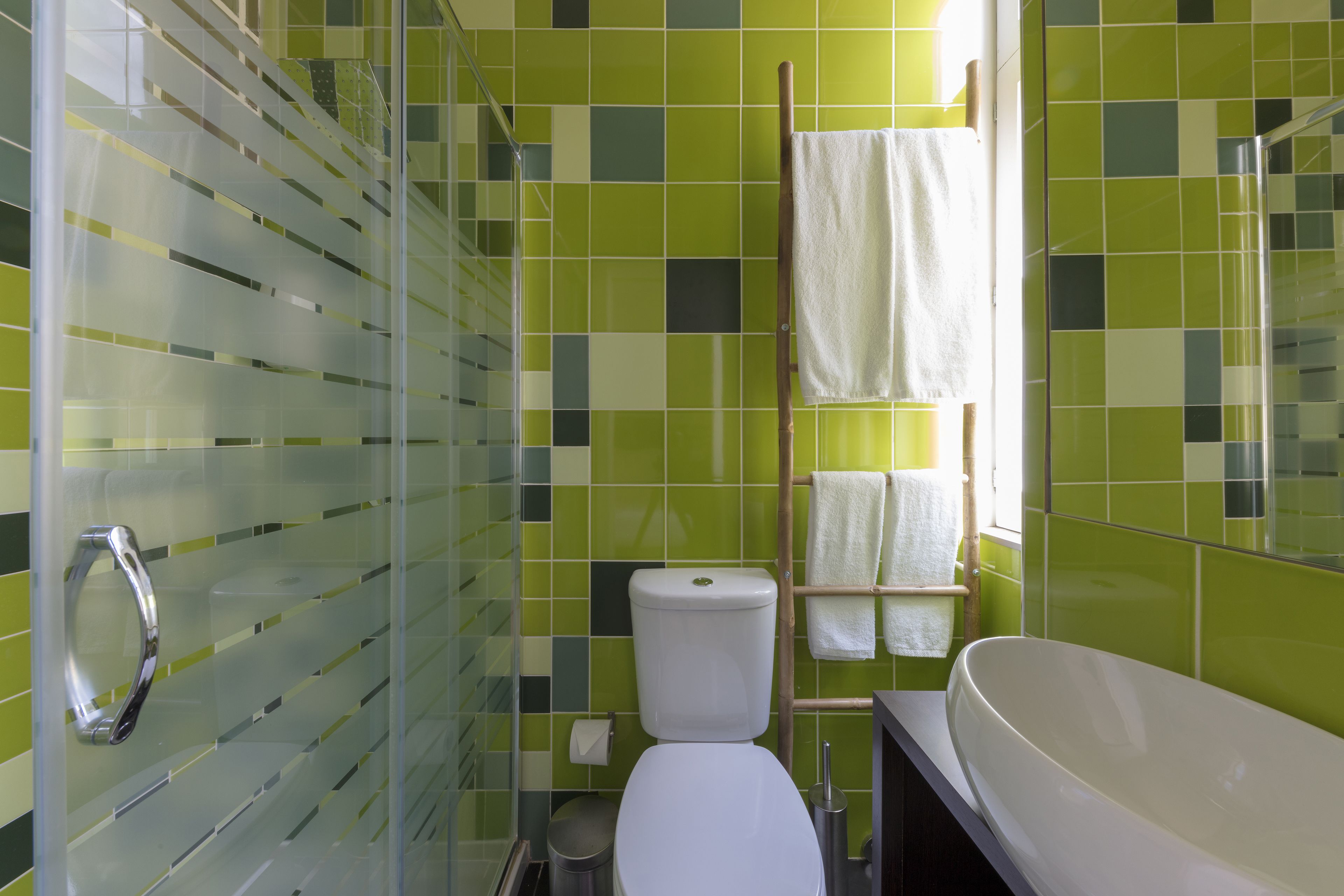 Een badkamer met een glazen douchecabine, een wit toilet en een groot, wit bad.