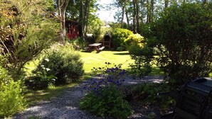 Ein Garten mit Picknicktisch und einem roten Gebäude im Hintergrund.