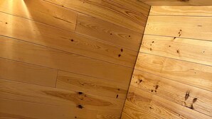 Interior de madera con un banco y una caja de almacenamiento con piedras.