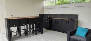 Une cuisine compacte comprenant un coin bar, un évier et un réfrigérateur.