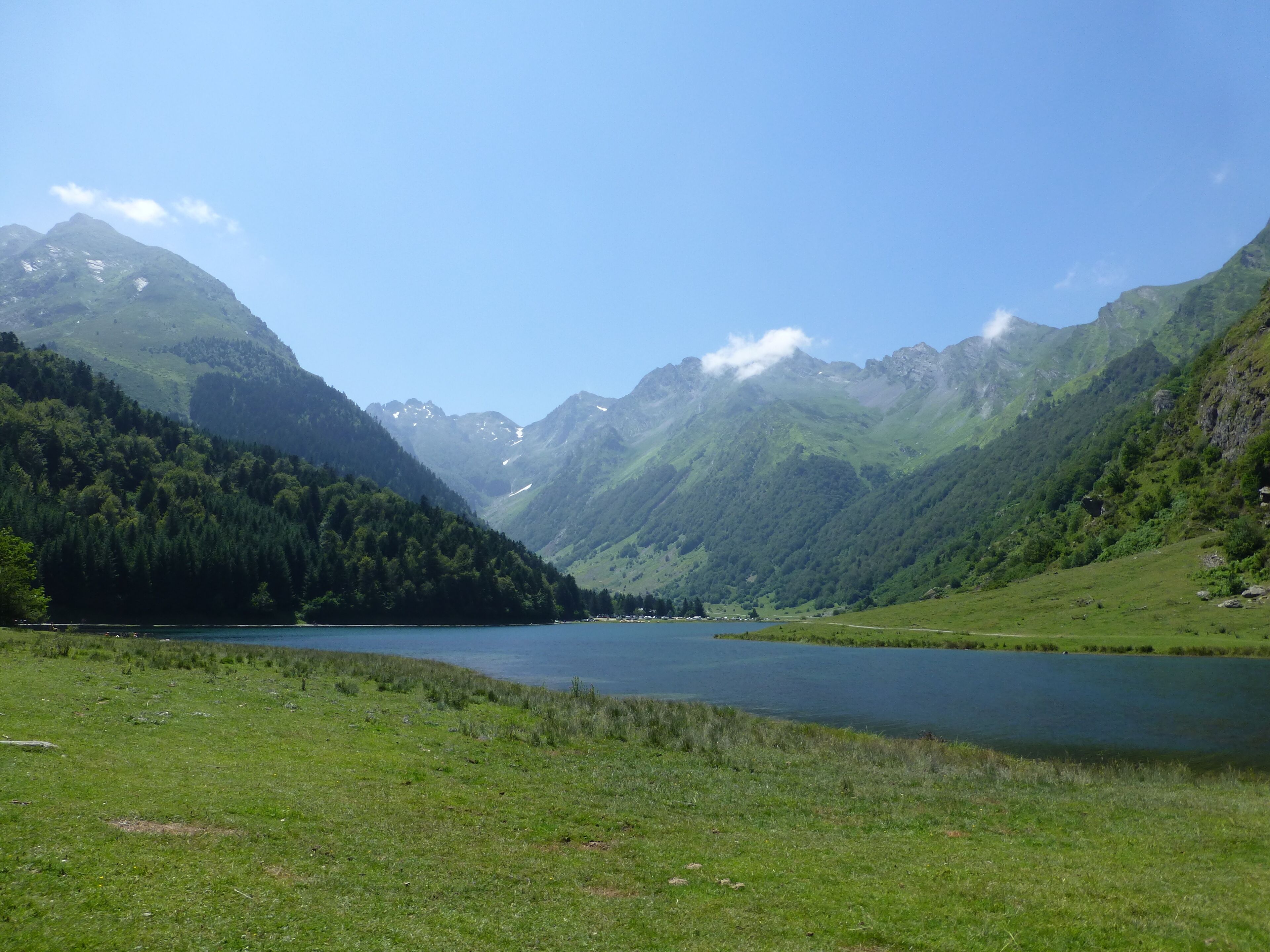 A mountainous landscape with a lake and forested hills.