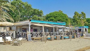 Um restaurante à beira-mar com área externa e espaço coberto.