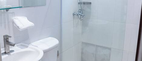 Un baño moderno con cabina de ducha de vidrio, inodoro y lavamanos.