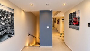 A modern hotel interior with a staircase, artwork on the walls, and a security camera. - Apart Hotel Bella Vida Suites e Apartamentos (Cairu)
