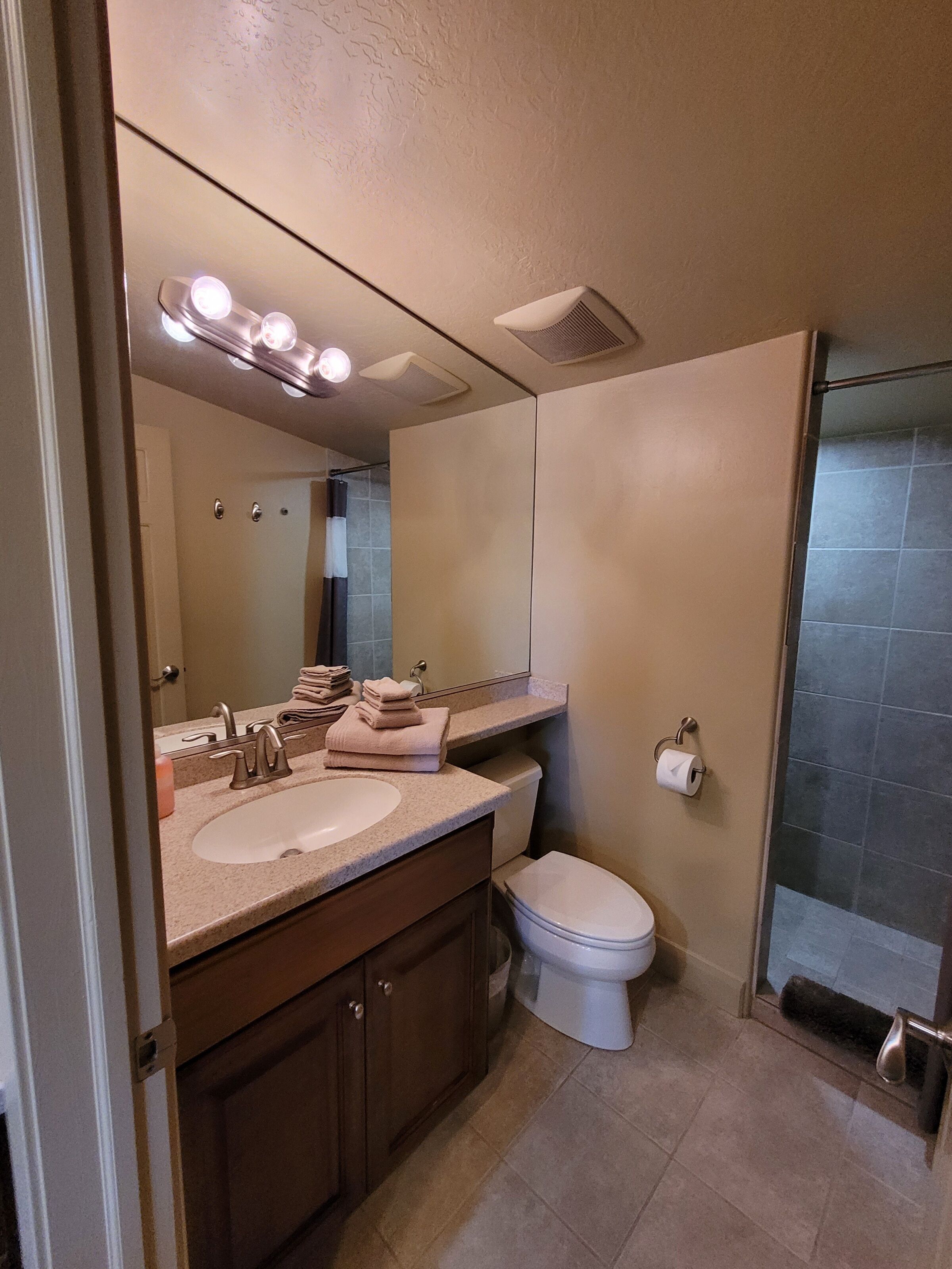 Une salle de bain moderne avec un lavabo, un miroir et des toilettes.