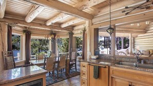 Una cocina rústica con vigas de madera, suelo de piedra y vistas al exterior.