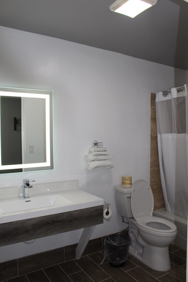 A modern bathroom with a white sink, mirror, and toilet. - ERTH INN by AGA Los Angeles (Los Angeles)