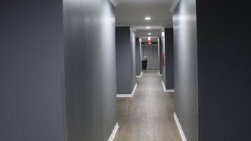 A long, narrow hallway with dark walls and wooden flooring.