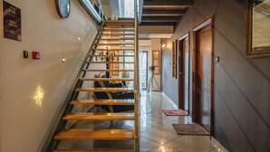A staircase with wooden steps and metal railings, leading to a landing with a view of the outdoors. - Hotel Atrium (Niksic)