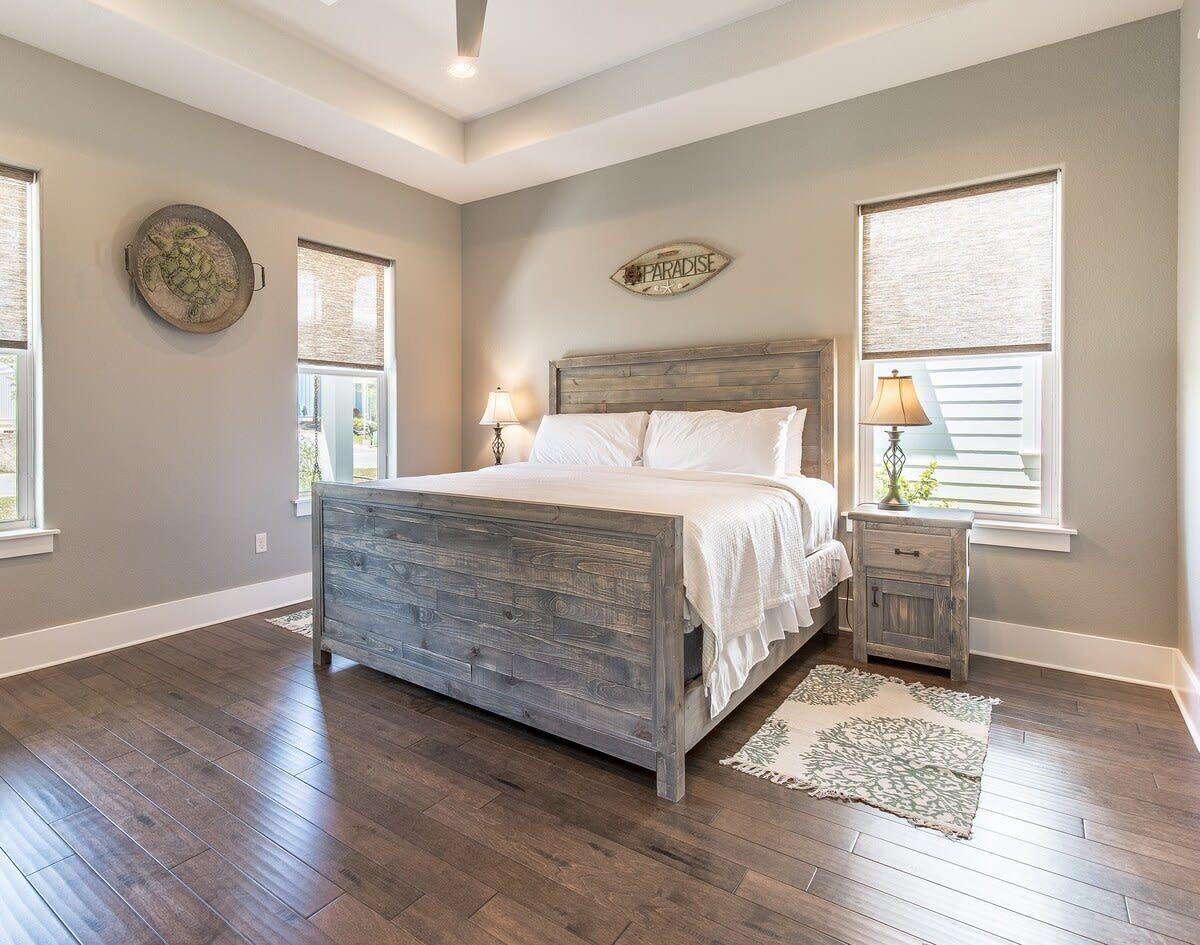 A bedroom with a wooden bed, a nightstand, a lamp, and a decorative wall piece.
