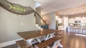 Une cuisine spacieuse, dotée d’appareils électroménagers modernes, et un coin repas avec une table et des bancs en bois.