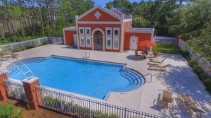 A swimming pool with a surrounding deck, lounge chairs, and a building with a red facade. - Huge (~2,700 SqFt) Home! Golf Cart, 6 Bikes! Beach & Pool Nearby! ~ Shore Thing at Frangista Beach (Miramar Beach)